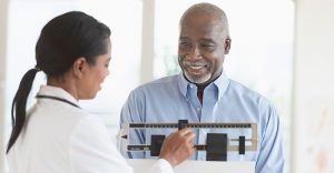 Mature man on scale, getting weighed